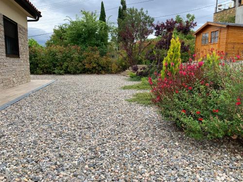 a garden with rocks and flowers next to a house at La Caseta d'Àger in Ager