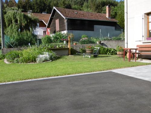 a yard with a house and a driveway at Chez Catherine et Roger in Brouvelieures