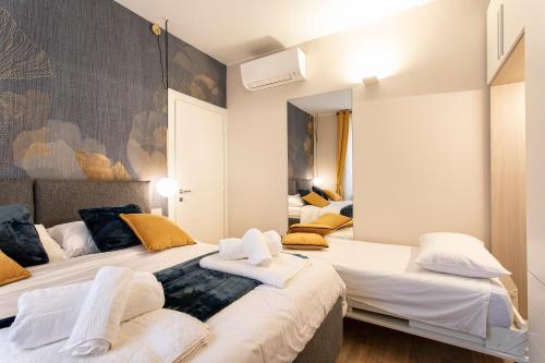 a bedroom with two beds with white sheets and yellow pillows at casapalestro8#2 in Modena