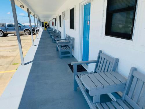 a row of blue benches next to a building at Sand Dollar Motel in Atlantic Beach