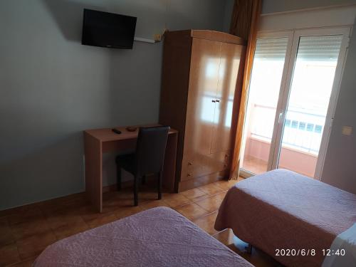 a room with a desk and a chair and a television at Hotel Europa in Tomelloso