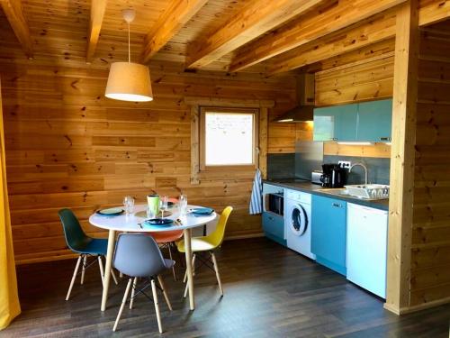 une cuisine avec une table et des chaises dans une cabine dans l'établissement Appart 50m2 4 à 5 pers dans Chalet de charme, à Vimines