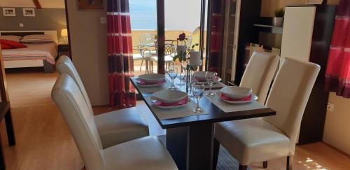 a dining room with a table with chairs and a room with a bed at Apatmani Milena in Opatija