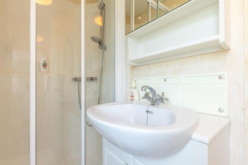 a bathroom with a white sink and a shower at Ubytování v Lednici in Lednice