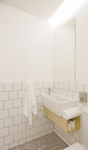a white bathroom with a sink and a mirror at Margueda in Alcains