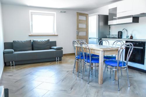 kuchnia i salon ze stołem i krzesłami w obiekcie Apartamenty Mazury w mieście Mrągowo