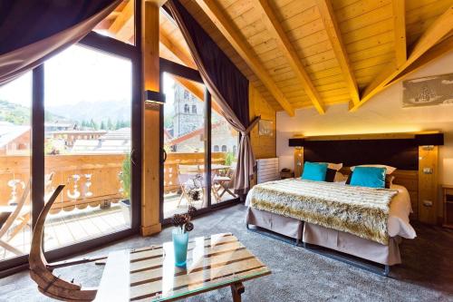 a bedroom with a bed and a large window at Les Airelles in La Clusaz