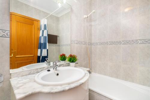 un baño con lavabo y bañera en Jardins da Rocha BeachView by Encantos do Algarve 19A, en Portimão