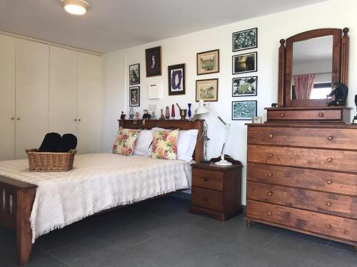 a bedroom with a bed and a dresser and a mirror at Sweet n’ Boujee Studio Apartment with Varenda in Paphos City