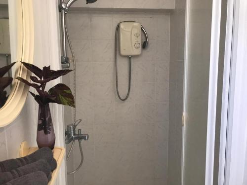 um chuveiro na casa de banho com um telefone na parede em Sweet n’ Boujee Studio Apartment with Varenda em Pafos