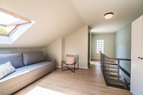a living room with a couch and a staircase at Helka Ház in Siófok