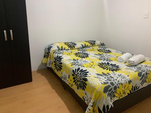 ボゴタにあるApto cerca del CC Titan Plaza 102のベッドルーム1室(黄色と黒の毛布付きのベッド1台付)