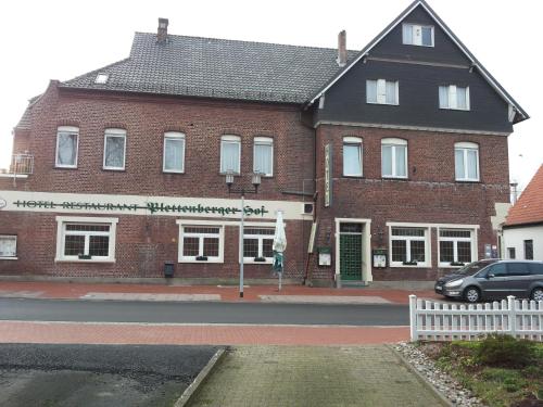 a red brick building with a white fence in front of it at Plettenberger Hof in Nordkirchen