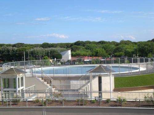 a building with a swimming pool next to a field at Mar y Soles in Cavallino-Treporti