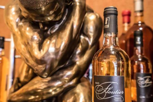 a bottle of wine next to a bronze statue at Grand Hôtel de Nîmes 4 étoiles in Nîmes