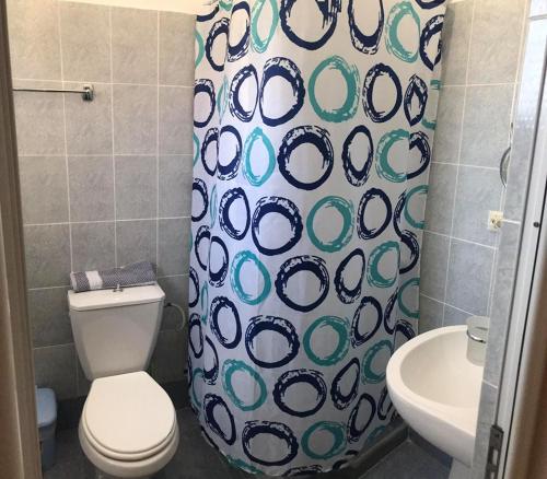 łazienka z toaletą i zasłoną prysznicową w obiekcie Victoria Apartments w mieście Ksamil