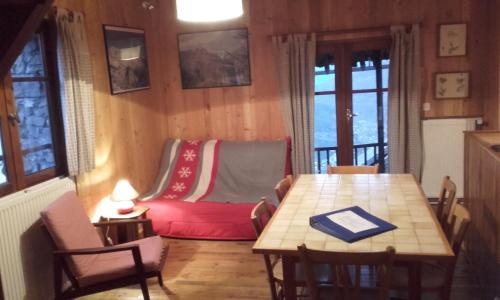 a living room with a table and a red couch at Gîtes Vallouise Ecrins in Vallouise