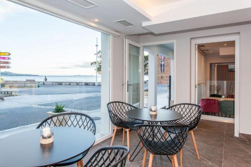 un patio con 2 mesas y sillas y vistas al agua en Mar do Ézaro - Boutique Hotel, en Ézaro