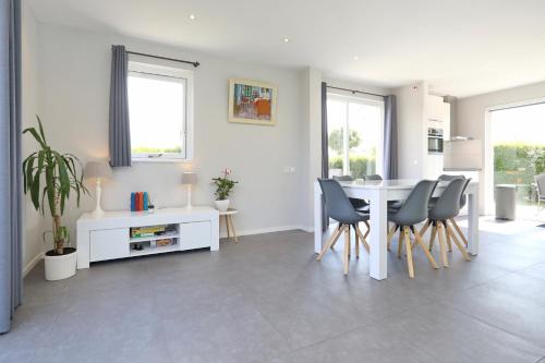 a living room with a white table and chairs at Paleisje Noordwijk in Noordwijk