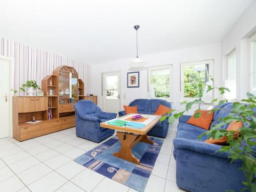 a living room with two blue couches and a table at Apartment in Densberg with terrace in Densberg