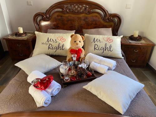 a teddy bear sitting on a bed with a tray of food at C-elena Suite in Terra