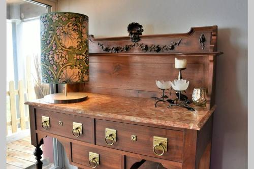 un comò in legno con una lampada sopra di Casa do Moinho de Vento a Leça da Palmeira