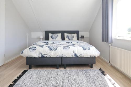 een witte slaapkamer met een bed met een tapijt bij Paleisje Noordwijk in Noordwijk