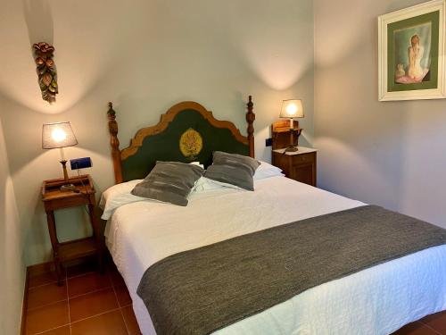 a bedroom with a large bed with two lamps at Apartamentos Alquitara in Potes