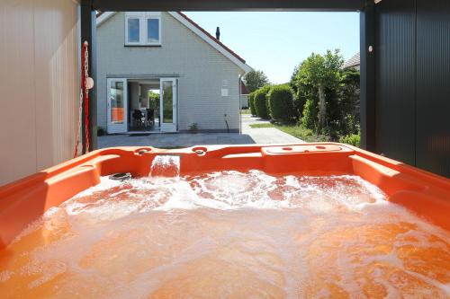 a tub filled with water in a yard at Paleisje Noordwijk in Noordwijk