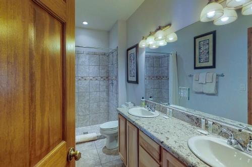 a bathroom with two sinks and a toilet and a shower at Ace Condos in Pagosa Springs