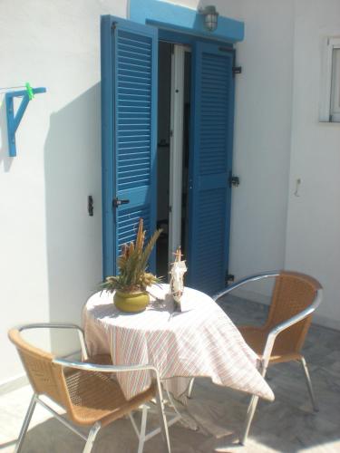 a table with chairs and a blue door at Hotel Rea in Naxos Chora