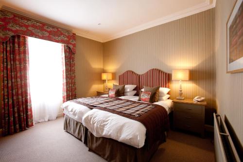 a hotel room with a bed and a window at Burt's Hotel in Melrose
