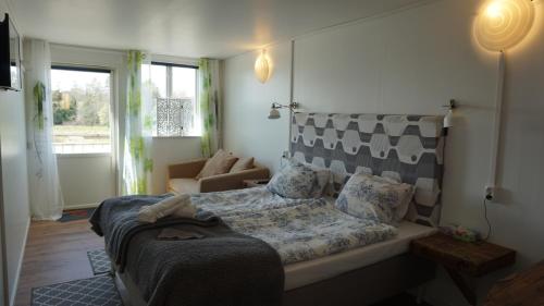 a bedroom with a bed and a couch and a window at Bottna Inn in Gerlesborg