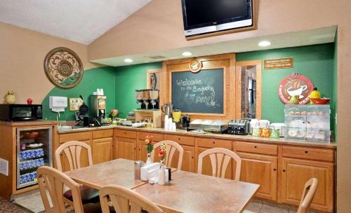 a kitchen with a table and a chalkboard on the wall at AmericInn by Wyndham Charlevoix in Charlevoix