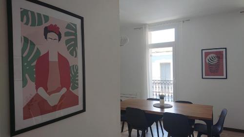 une salle à manger avec une table et un tableau au mur dans l'établissement L'Amaryllis, beau T4 contemporain et lumineux en Centre Ville 3 étoiles, à Sète