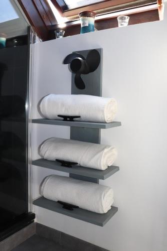 - un ensemble de serviettes sur les étagères de la salle de bains dans l'établissement CHERBOURG MARITIME, à Cherbourg en Cotentin