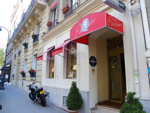 ein Motorrad, das vor einem Gebäude geparkt ist in der Unterkunft Hôtel Poussin in Paris