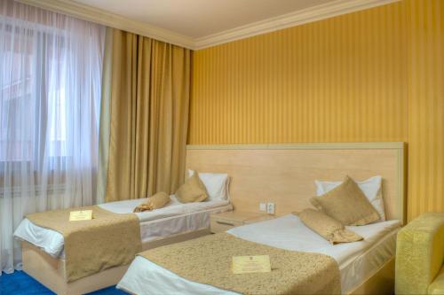 a hotel room with two beds and a window at King Hotel Astana in Astana