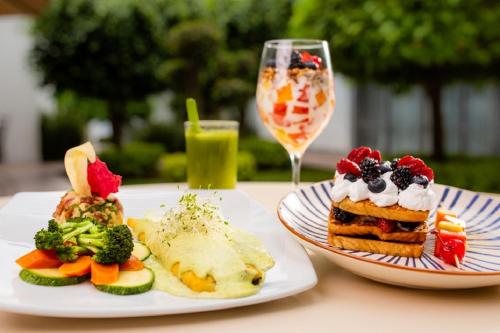 a table with two plates of food and a glass of wine at Hotel Horizon & Convention Center in Morelia