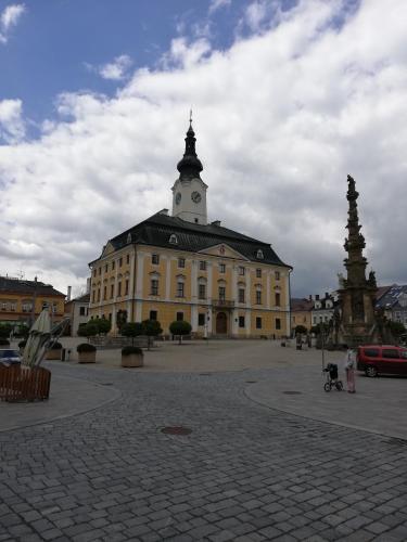 a large yellow building with a clock tower on top at Apartmán Polička in Polička