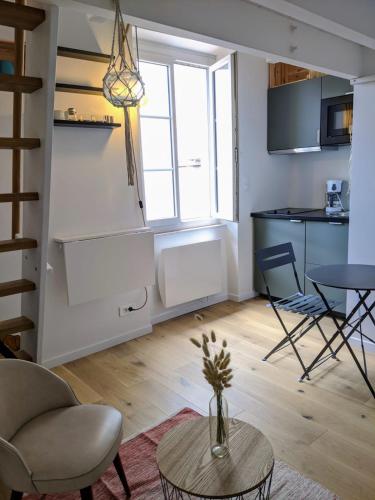 un salon avec une table et une cuisine dans l'établissement Dalhia Studio centre ville Biarritz, à Biarritz