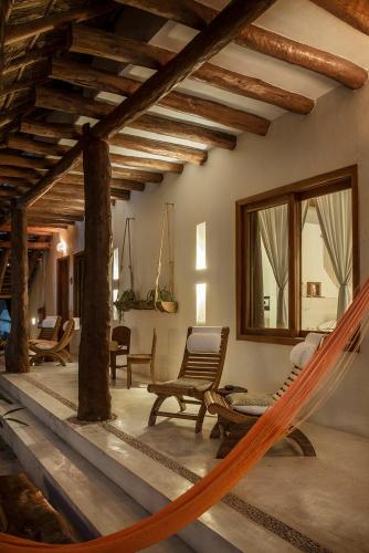 a room with a hammock in a house at Tierra del Mar Hotel - Adults Only in Holbox Island