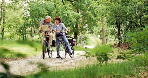 two people riding bikes on a dirt road at Hotel & Restaurant - Auberge De Hilver in Diessen