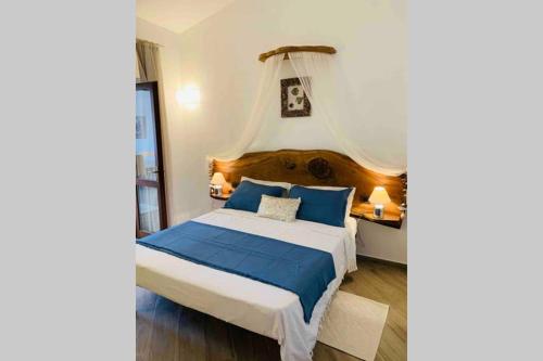 a bedroom with a large bed with blue pillows at Appartamento IL CANNETO in Cannigione