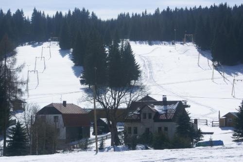 a snow covered ski slope with a ski lift at Penzion "Apartmány U Semušky" in Pernink