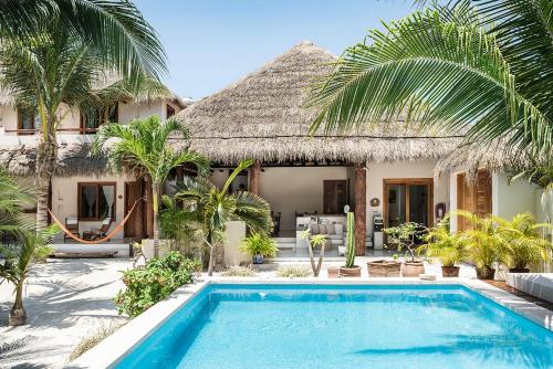 une villa avec une piscine en face d'une maison dans l'établissement Tierra del Mar Hotel - Adults Only, à Holbox