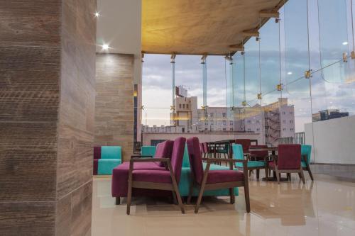 a restaurant with chairs and tables and a large window at Hotel Kavia Monterrey in Monterrey