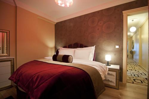 イスタンブールにあるAymira Suite Hotelのベッドルーム1室(赤毛布付きの大型ベッド1台付)