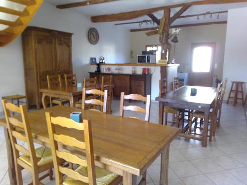 cocina y comedor con mesas y sillas de madera en Domaine de Pimont, en Yerville