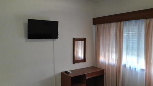 a room with a television and a dresser at Hotel S. Gabriel in Porto